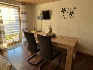 a dining room table with chairs and a television on the wall at Ferienwohnung Köppl in Lam
