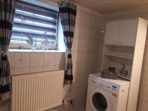 a small bathroom with a washing machine and a window at Ferienwohnung Köppl in Lam