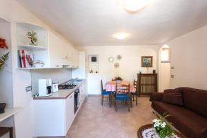a kitchen and living room with a couch and a table at Casa Rita app 4 in Tremosine Sul Garda +17 photos