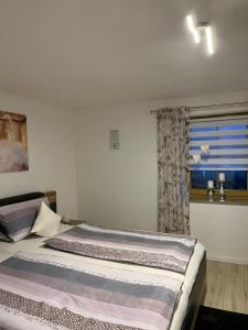 two beds in a room with a window at Ferienwohnung Köppl in Lam