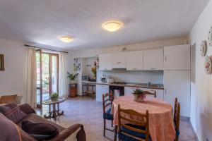 a kitchen and living room with a table and a couch at Casa Rita app 4 in Tremosine Sul Garda