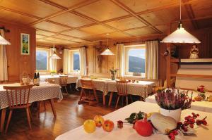 a dining room with tables and chairs and windows at Huberhof App Gala in Feldthurns