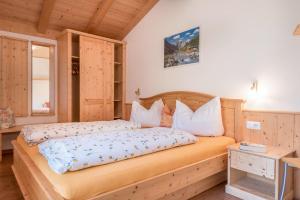 a bedroom with a wooden bed in a room at Huberhof App Gala in Feldthurns