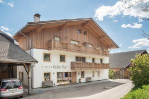 a large white building with a wooden roof at Huberhof App Gala in Feldthurns