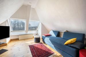 a living room with a blue couch and a tv at Voßberg großes Ferienhaus in Grömitz