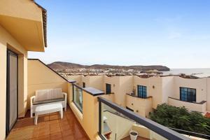 a balcony with a chair and a view of the ocean at Casa Otoño in Lajita