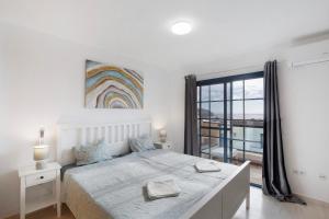 a white bedroom with a bed and a large window at Casa Otoño in Lajita
