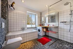 a bathroom with a tub and a washing machine at Voßberg großes Ferienhaus in Grömitz +26 photos