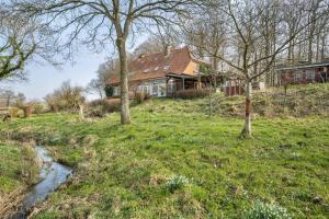 a house on a hill with trees in a field at Voßberg großes Ferienhaus in Grömitz