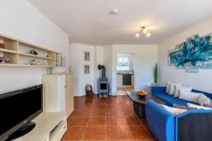a living room with a blue couch and a tv at Apartment Ayleen in Boll