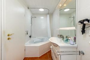 a white bathroom with a tub and a sink at Apartment Ayleen in Boll +15 photos