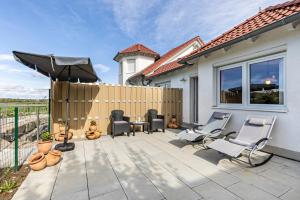 a patio with chairs and an umbrella and a fence at Apartment Ayleen in Boll