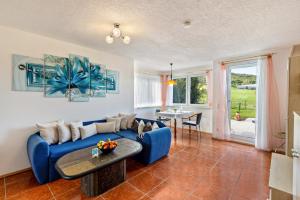 a living room with a blue couch and a table at Apartment Ayleen in Boll