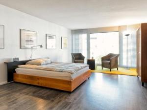 a bedroom with a bed and two chairs in it at Hochburger 21 in Emmendingen
