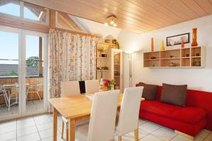 a living room with a red couch and a table at Ferienwohnungen Shamal in Reutin