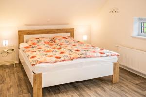 a bedroom with a bed with a floral comforter at Fewo-llojan in Wiesmoor