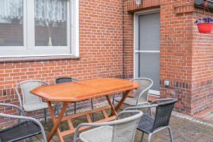 a wooden table with four chairs around a brick building at Fewo-llojan in Wiesmoor
