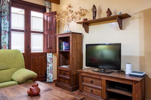 a living room with a television on a wooden table at Las Puentes 1 in Candelario