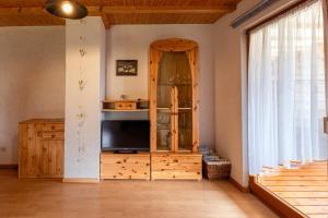 a living room with a tv and a wooden cabinet at Hinterhauensteinhof in Hornberg