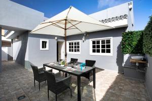 a patio with a table and chairs and an umbrella at La Carpinteria in Tacoronte