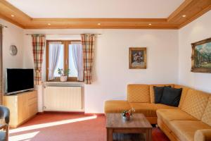 a living room with a couch and a tv at Alpenblick Tilly - Fewo Lautersee 3 in Krün