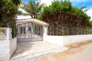 a gate to a house with palm trees at Villetta del Salento 1 in Racale +11 photos
