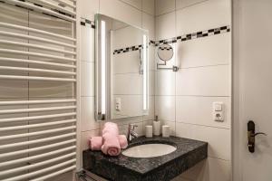 a bathroom with a sink and a mirror at Alpenblick Tilly - Fewo Lautersee 3 in Krün +10 photos