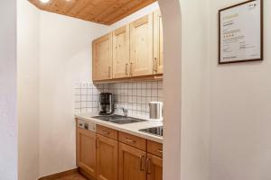a kitchen with wooden cabinets and a sink at Alpenblick Tilly - Fewo Lautersee 3 in Krün