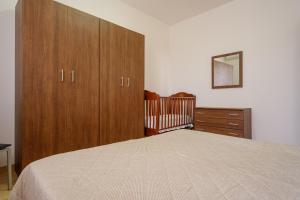 a bedroom with a bed and a dresser and a crib at Villetta del Salento 1 in Racale