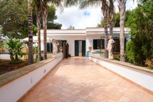 a house with palm trees and a walkway at Villetta del Salento 1 in Racale