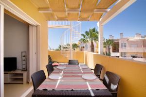 a dining table on a balcony with a view of the city at Royal Cabanas Golf 89 in Cabanas de Tavira