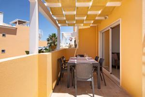 a dining room with a table and chairs on a balcony at Royal Cabanas Golf 89 in Cabanas de Tavira