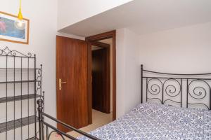 a bedroom with a bed and a wooden door at Vecchio Marino H4 in Palau