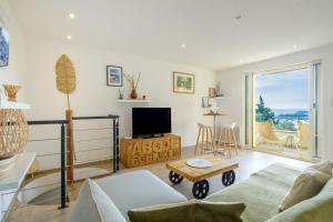 a living room with a couch and a tv at Duplex 2 chambres Golden Sun in Théoule-sur-Mer
