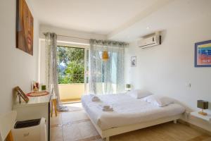 a bedroom with a large bed and a window at Duplex 2 chambres Golden Sun in Théoule-sur-Mer