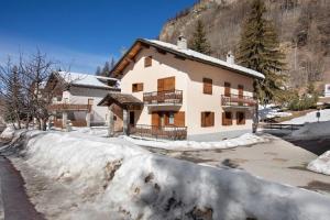 a house in the snow in front of a mountain at La Maison du Bonheur Lillaz in Cogne