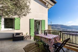 a patio with a table and chairs on a balcony at La Casa In Collina Con Vista in Grezzana