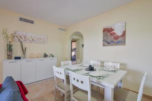 a kitchen and dining room with a white table and chairs at Saadia Golf in Huelva