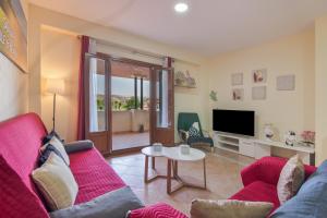 a living room with a red couch and a table at Saadia Golf in Huelva