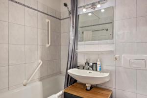 a white bathroom with a sink and a bath tub at 2 Zimmer Appartement mit Pool in Schluchsee +19 photos