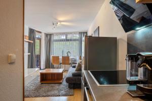 a kitchen and living room with a couch and a table at 2 Zimmer Appartement mit Pool in Schluchsee