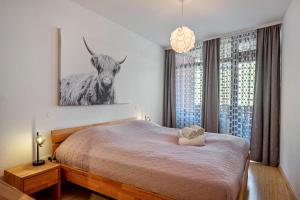 a bedroom with a bed with a picture of a cow at 2 Zimmer Appartement mit Pool in Schluchsee