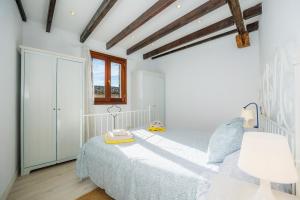 a white bedroom with a bed and a window at Apartamento Can Roses in Moscari