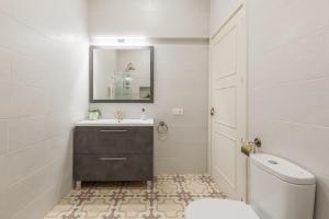 a bathroom with a toilet and a sink and a mirror at Casa Palma 12 in Vilafranca del Penedès +24 photos