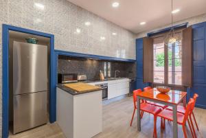 a kitchen with a refrigerator and a table with chairs at Casa Palma 12 in Vilafranca del Penedès