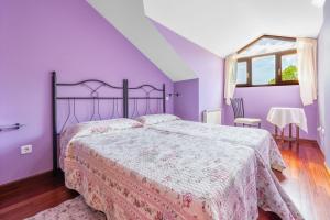 a bedroom with purple walls and a large bed at Quintanal de Villacarriedo in Villacarriedo