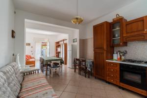 a living room with a couch and a kitchen at Villa Tina a Torre Lapillo in Torre Lapillo