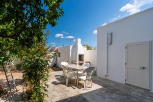 a patio with a white table and chairs at Villa Tina a Torre Lapillo in Torre Lapillo