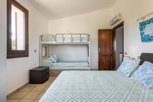 a bedroom with a bed and two bunk beds at villa Isabel 2 in Villasimius