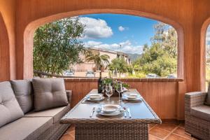 a patio with a table and chairs and a window at villa Isabel 2 in Villasimius